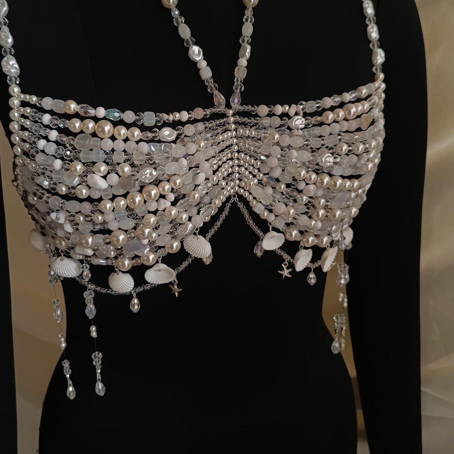 Zoomed in view of handmade pearl bralette necklace highlighting layered pearl strands and draped crystal chains
