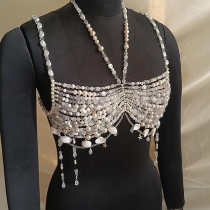 Handmade pearl beaded bralette necklace with crystals and shell charms displayed on black mannequin, mermaid inspired bridal body jewelry